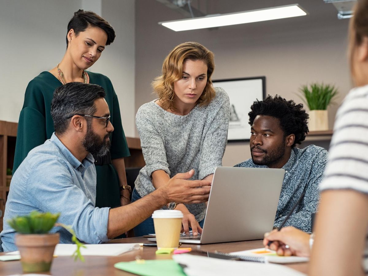 Equipo de consultores revisando un proyecto en torno a un computador