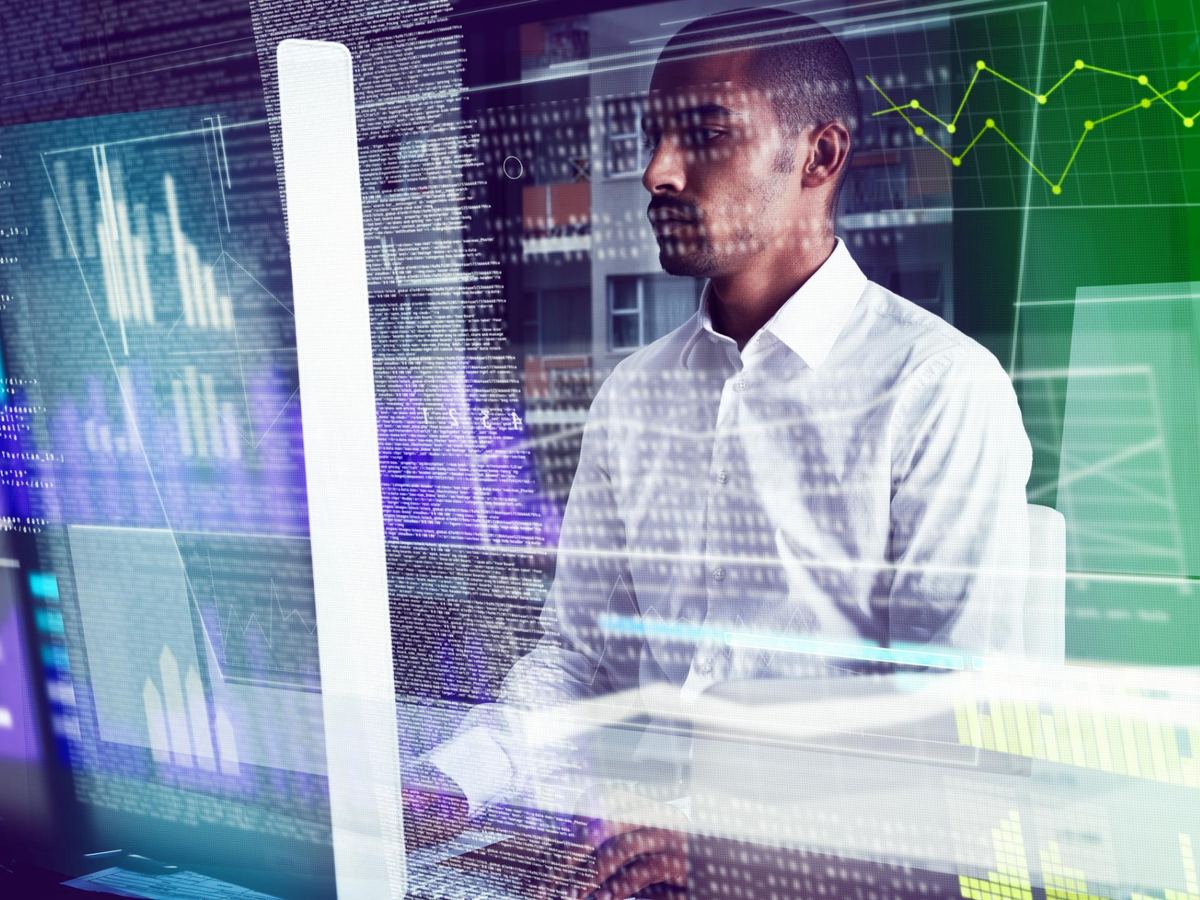 Especialista de TI trabajando frente a monitores con datos